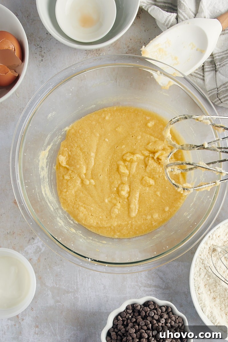 An overhead view showcases the perfectly mixed wet ingredients for Mini Chocolate Chip Bundt Cakes, a smooth, creamy base ready for the next additions.
