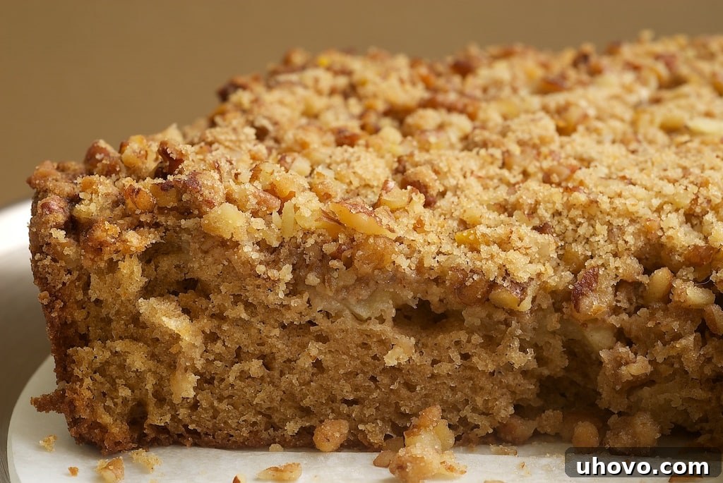 A stunning Sour Cream Pear Cake with Pecan Streusel, showcasing a light, simple cake adorned with fresh pears, crunchy nuts, and aromatic cinnamon, ready to be enjoyed as a perfect fall dessert. 