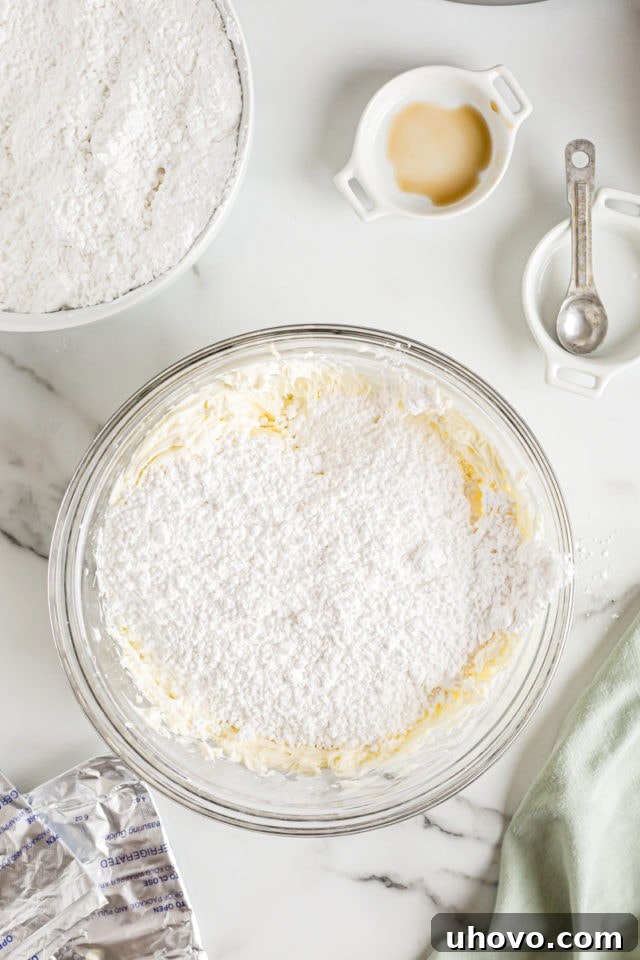 Overhead view of sifted confectioners' sugar in a bowl, ready to be mixed into the cream cheese and butter for the frosting.