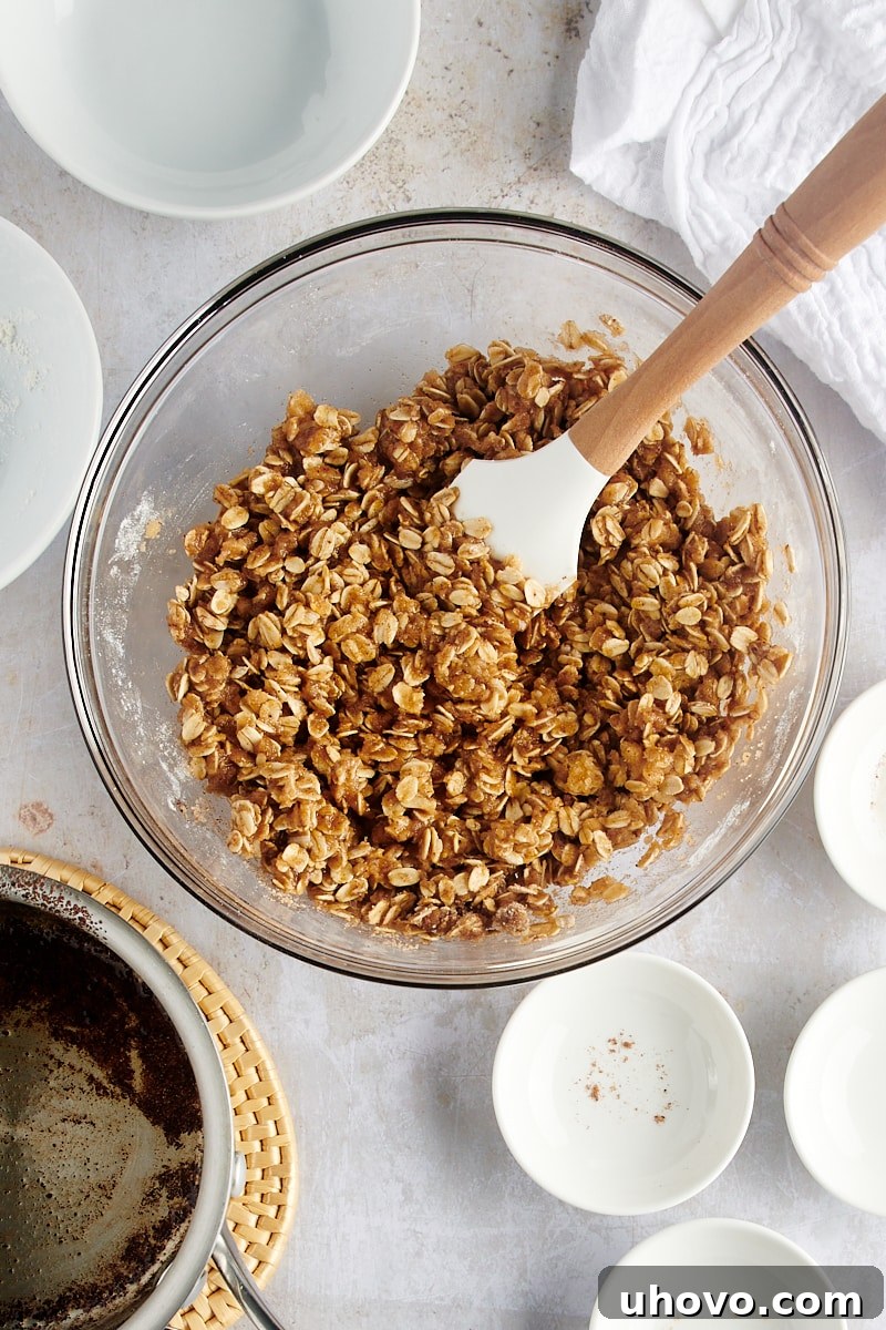 An inviting overhead view of the fully mixed topping for Brown Butter Pear Crisp, showcasing its perfect crumbly texture in a clear glass mixing bowl, ready for assembly.