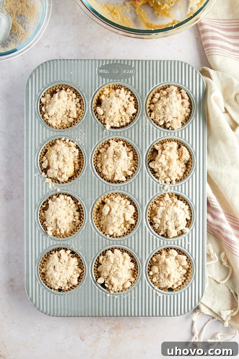 overhead view of Apple Cinnamon Muffin batter portioned and topped with crumb topping