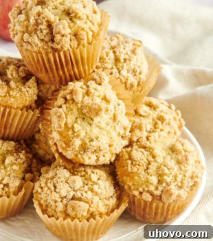 Apple Cinnamon Muffins piled on a white plate