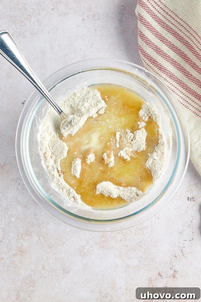 overhead view of melted butter added to dry ingredients for crumb topping