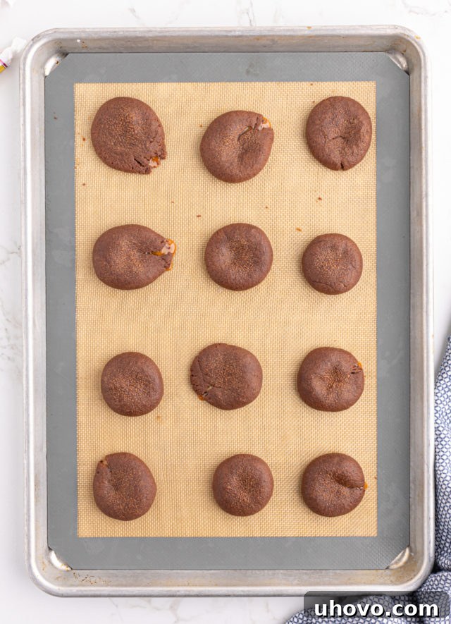 Overhead view of baked chocolate caramel cookies on silpat lined baking sheet