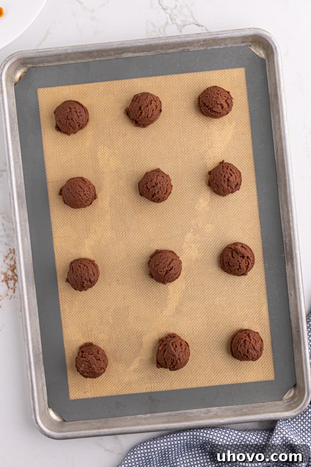 Balls of chocolate cookie dough on baking sheet