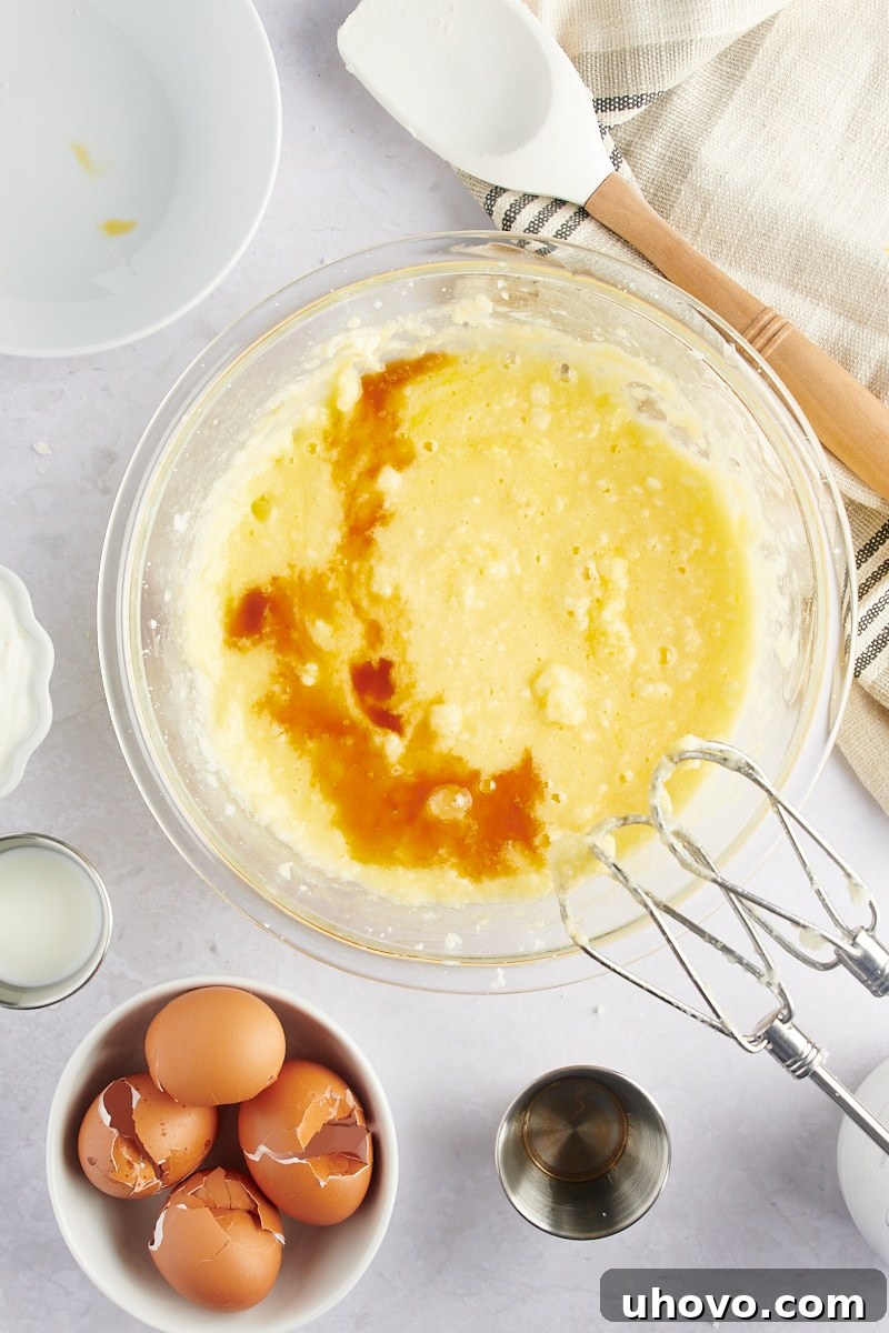 overhead view of vanilla extract being added to Marble Bundt Cake batter