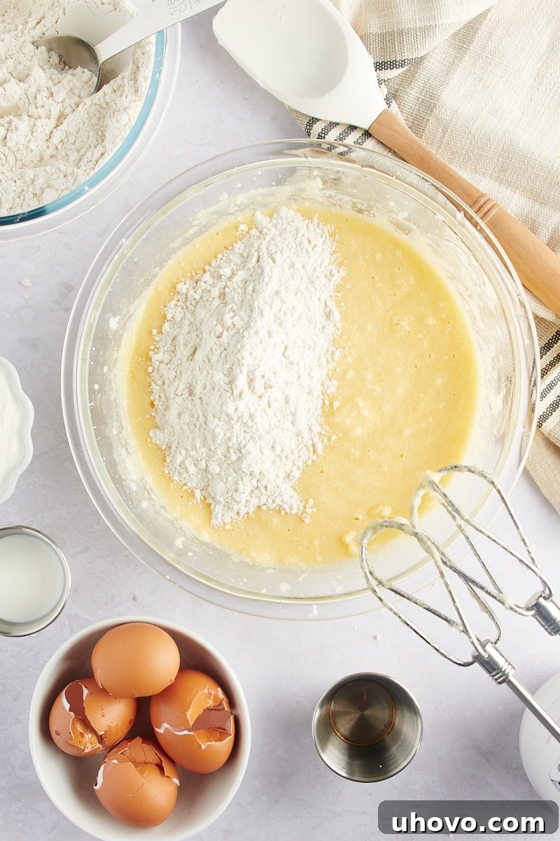 overhead view of flour mixture being added to Marble Bundt Cake batter