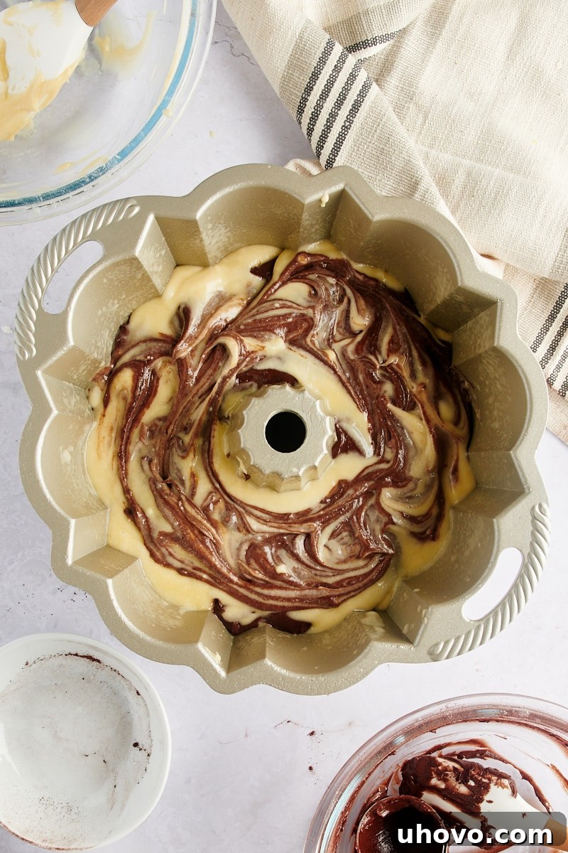 overhead view of Marble Bundt Cake batters swirled together in a Bundt pan, showing a beautiful pattern