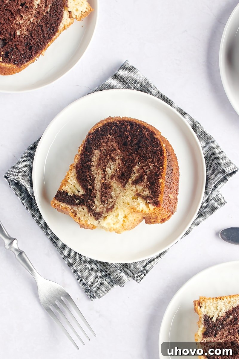 overhead view of a single slice of Marble Bundt Cake on a white plate, showcasing the swirl