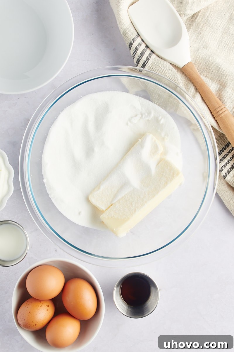 overhead view of butter and sugar in a glass mixing bowl before creaming