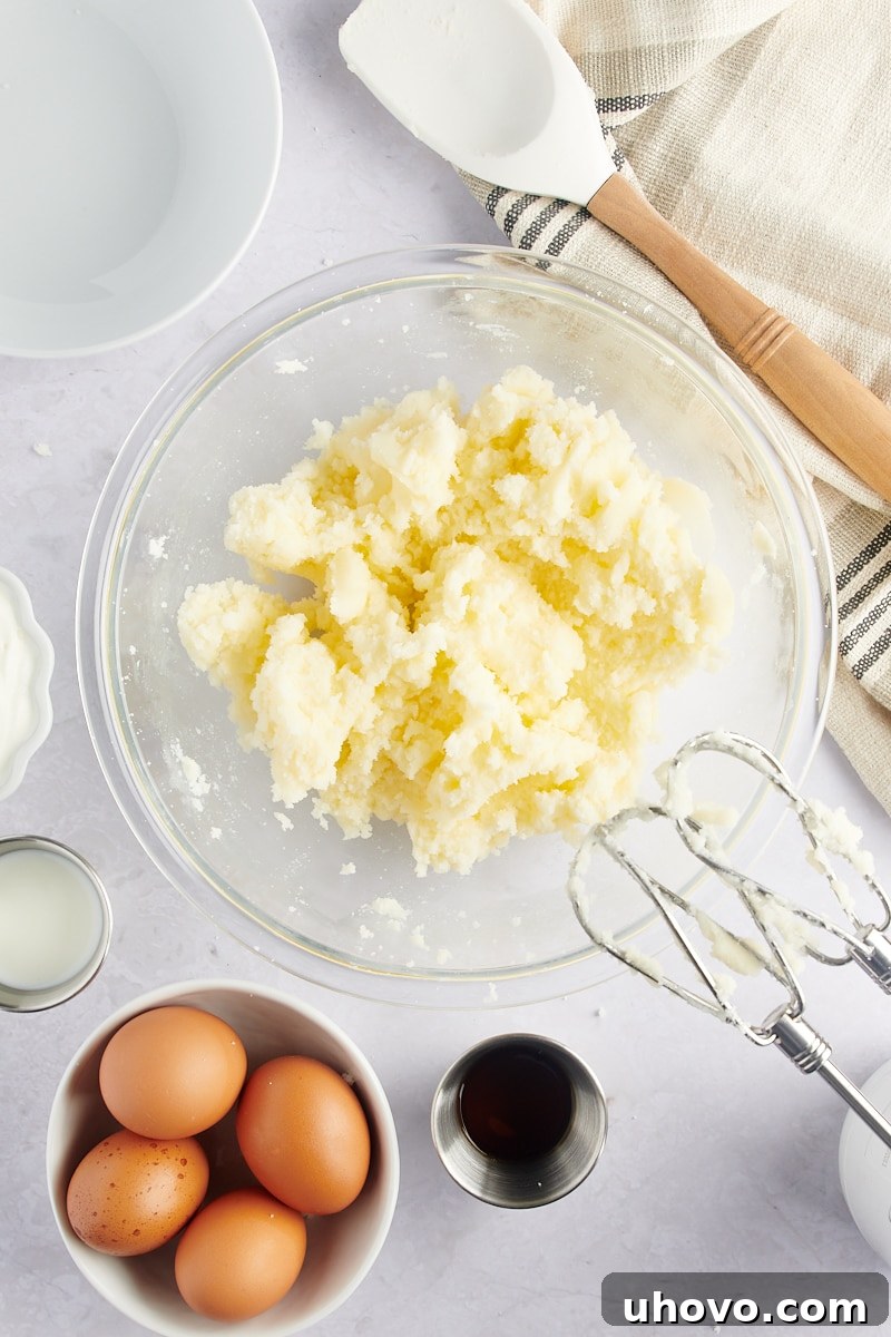 overhead view of creamed butter and sugar in a glass mixing bowl, light and fluffy