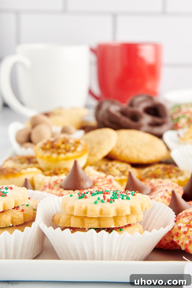 A vibrant selection of various homemade Christmas cookies beautifully arranged on a white tray, showcasing their festive colors and textures.