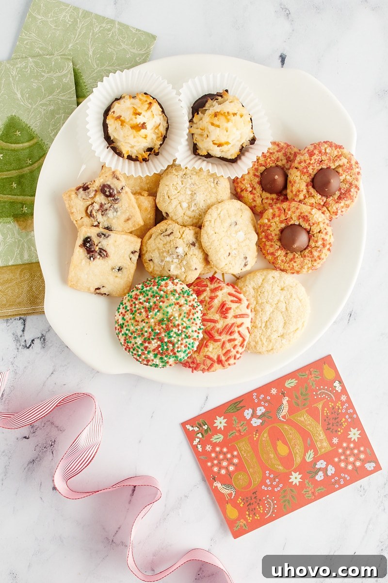 An overhead view of a festive Christmas cookie tray, featuring an array of cookies artfully arranged with napkins and ribbons for a thoughtful presentation.