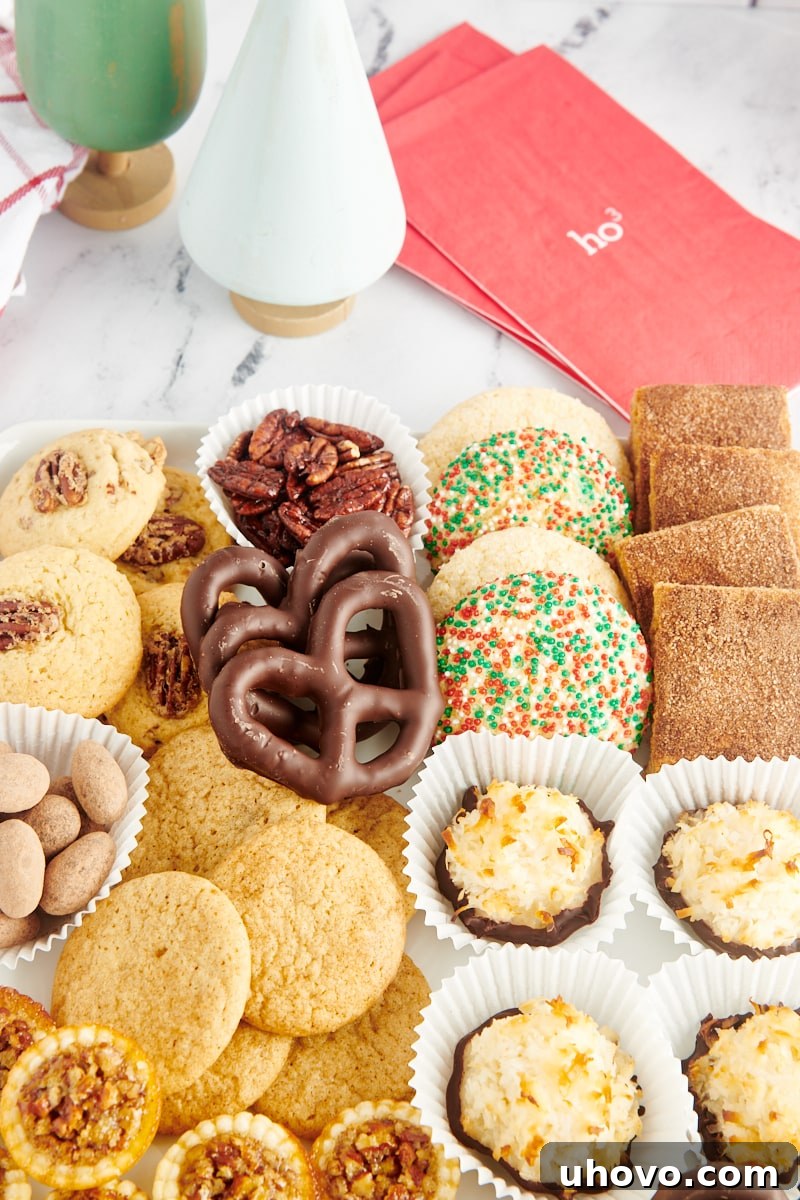 An artfully arranged assortment of homemade Christmas cookies displayed on a pristine white serving tray, highlighting their diverse shapes and decorations.