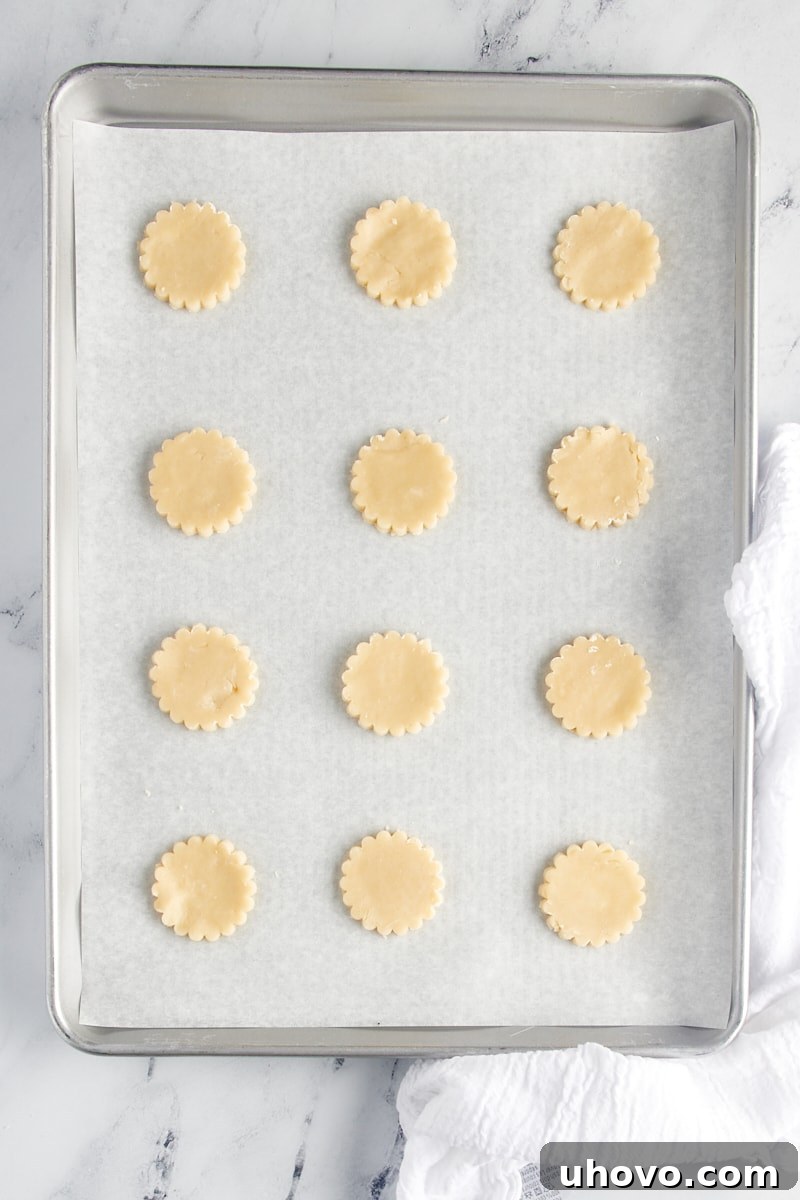 Shortbread cookie cutouts on a parchment-lined baking sheet.