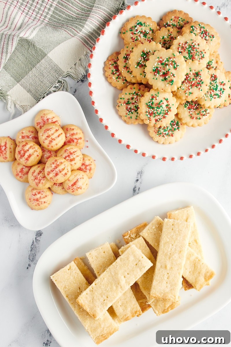 Overhead view of shortbread cookies in three different styles on white plates.