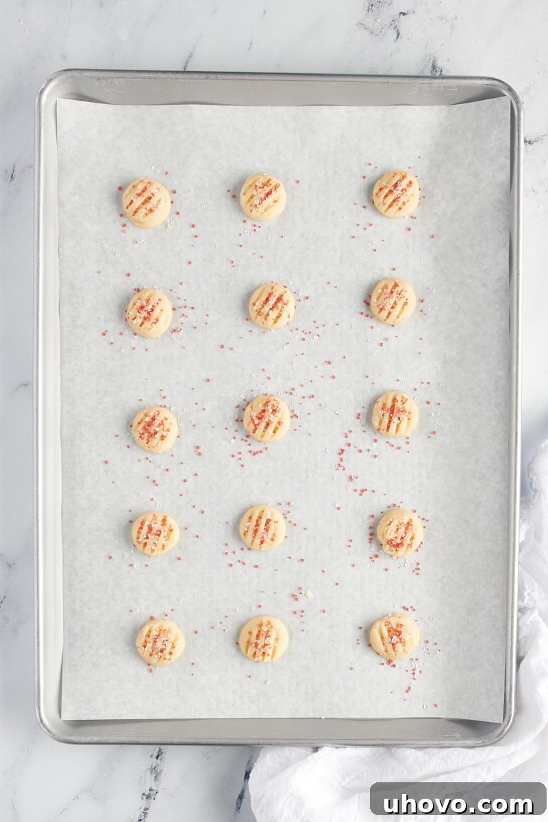 Overhead view of scooped shortbread cookie dough on a baking sheet.