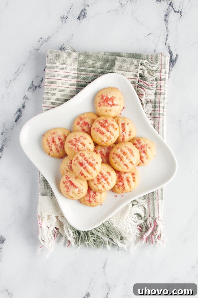 Overhead view of drop-style shortbread cookies on a white plate.