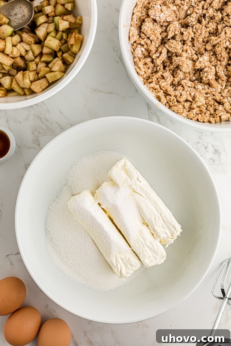 overhead view of cream cheese and sugar in a white mixing bowl