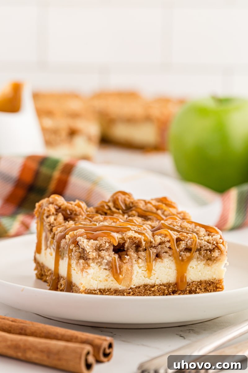a Caramel Apple Cheesecake Bar on a white plate with more bars on a plate in the background