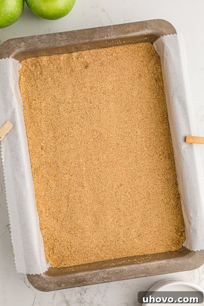 overhead view of graham cracker crust pressed into the bottom of a 9x13 pan