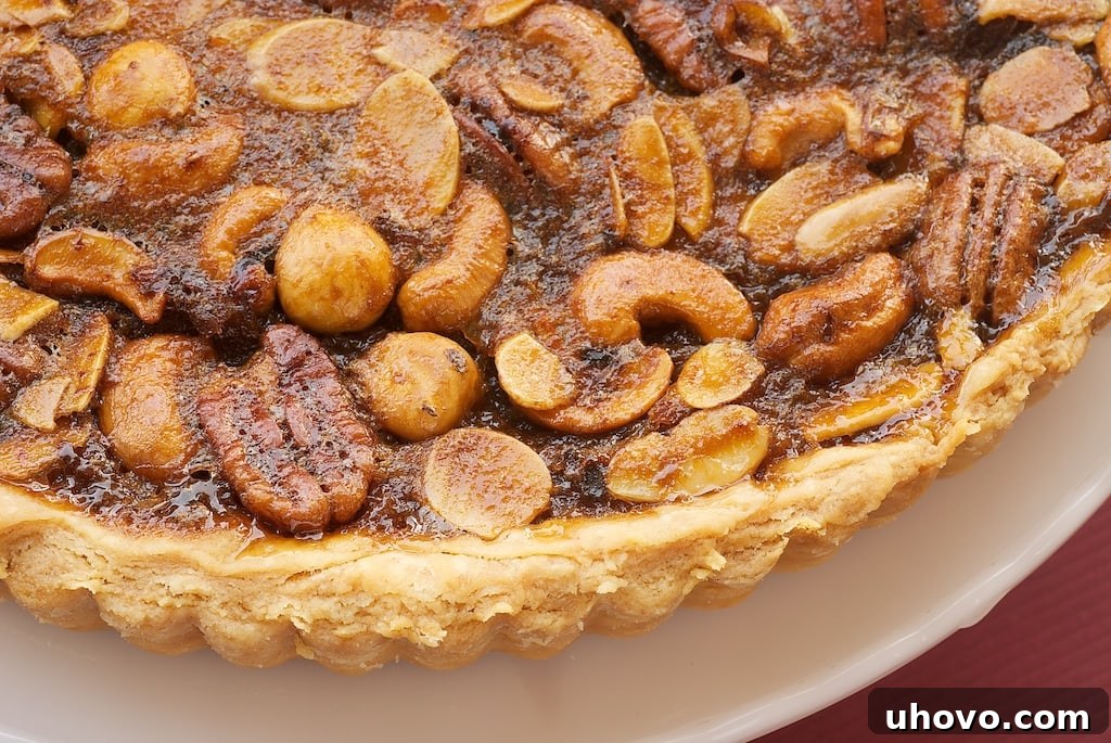 This Mixed Nut Tart boasts a perfectly sweet, irresistibly gooey, and deeply nutty filling nestled in a flaky, golden crust, making it a dessert masterpiece, ideal for any occasion.