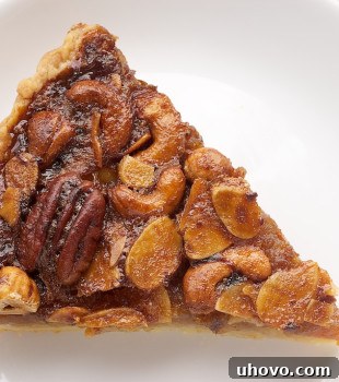 Mixed Nut Tart is a fabulous variation of traditional pecan pie, featuring a blend of delicious nuts and a gooey, sweet filling.