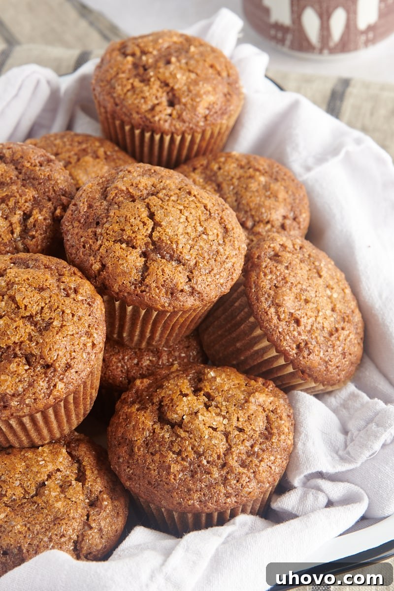 Piles of cozy, sweet, spiced gingerbread muffins on a cloth-lined tray, ready for holiday enjoyment and serving.