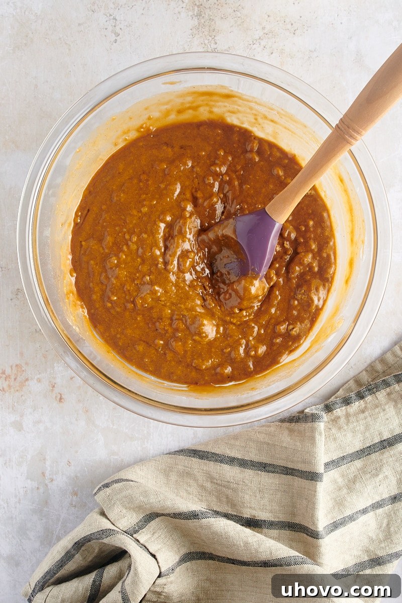 An overhead view of the fully mixed gingerbread muffin batter, showcasing its rich, thick consistency and readiness for baking, with minimal streaks.