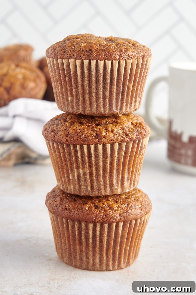 A perfectly arranged stack of three golden-brown gingerbread muffins, highlighting their fluffy texture and enticing crumb, ready to be enjoyed.