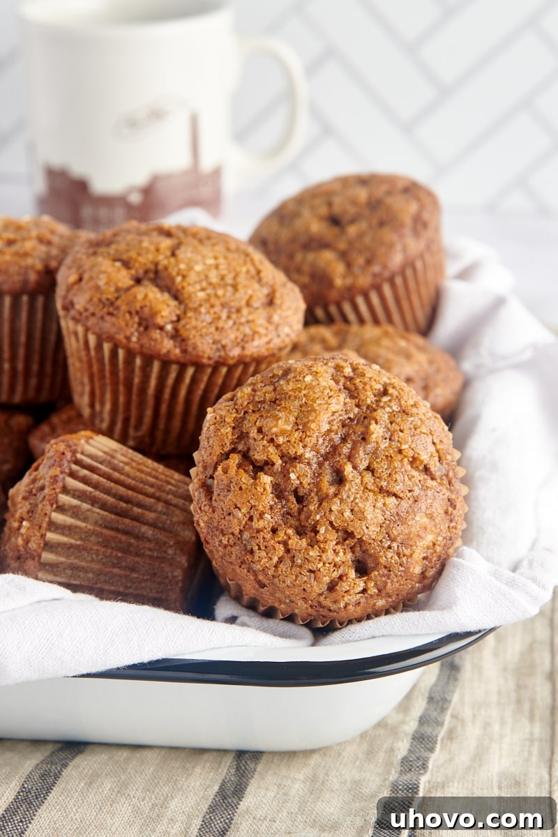 A charming close-up of several gingerbread muffins arranged invitingly in a white tray lined with a clean towel, perfect for serving.