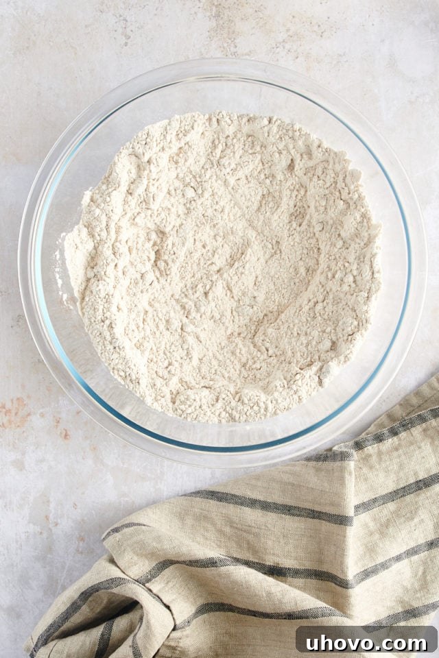 An overhead view of the thoroughly mixed dry ingredients, with a distinct well formed in the center, perfectly ready for the wet ingredients to be added.
