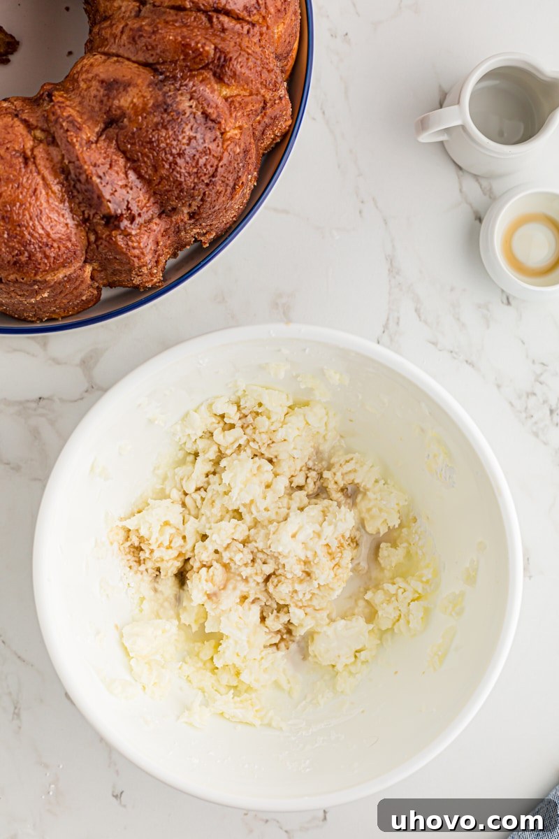 overhead view of milk and vanilla added to sweetened cream cheese mixture
