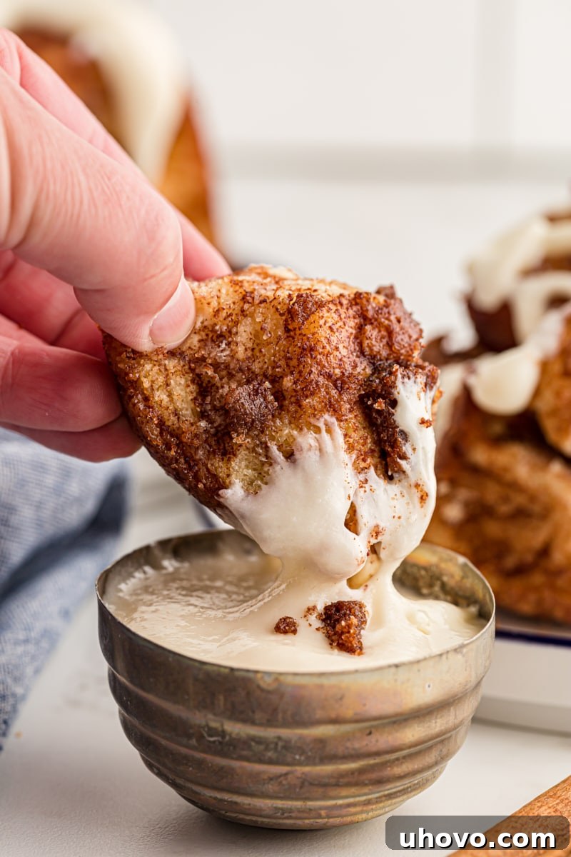 a piece of Monkey Bread dipped in cream cheese icing