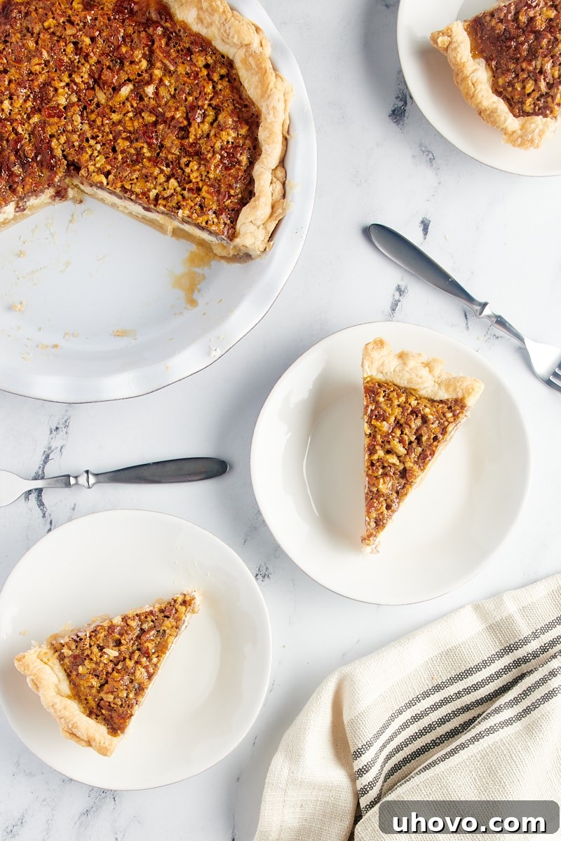 Slices of golden-brown Pecan Cheesecake Pie arranged on white plates.