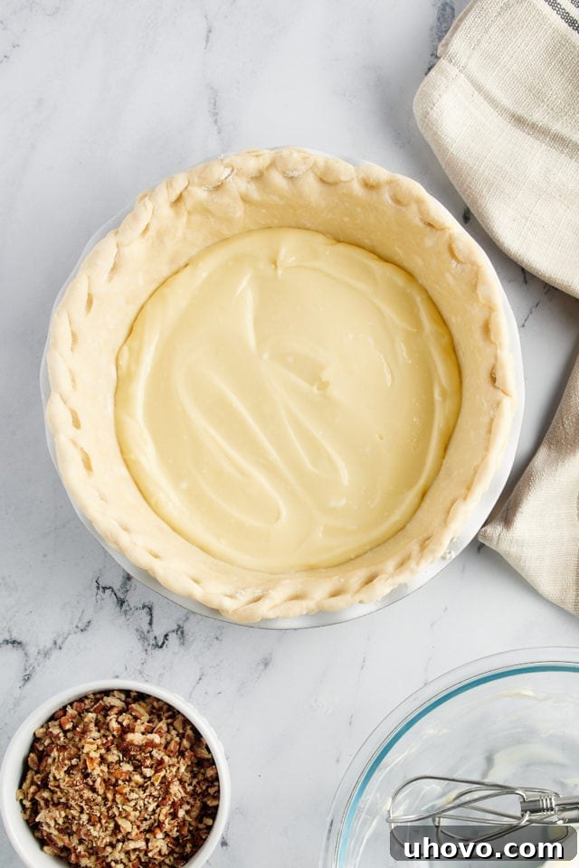 Carefully adding the cheesecake filling into the chilled pie crust.