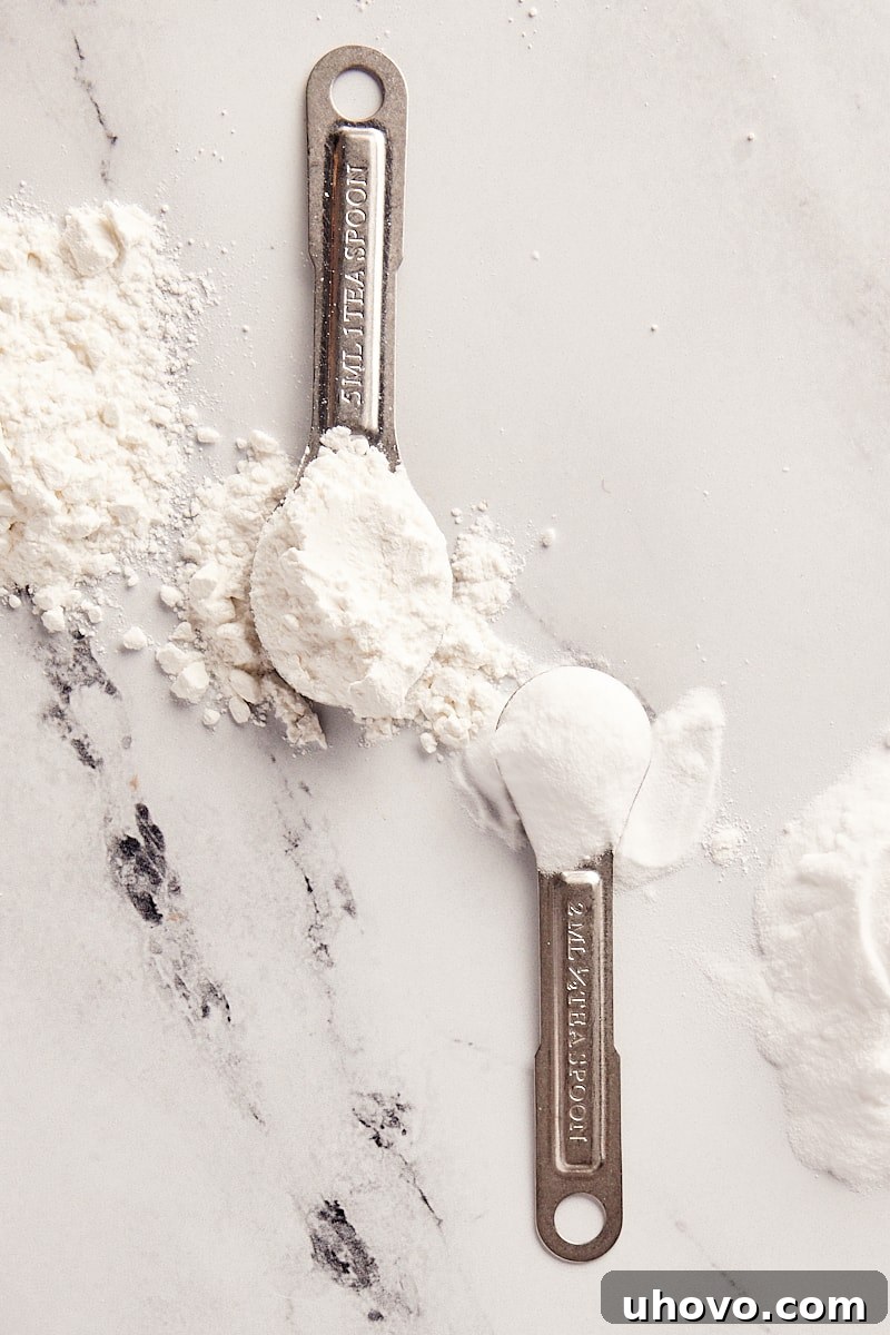 overhead view of baking powder and baking soda in measuring spoons