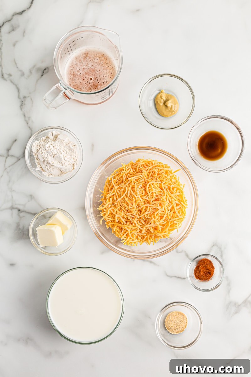 Overhead view of all the ingredients for a homemade beer cheese dip, including shredded cheese, beer, milk, and spices, neatly arranged.