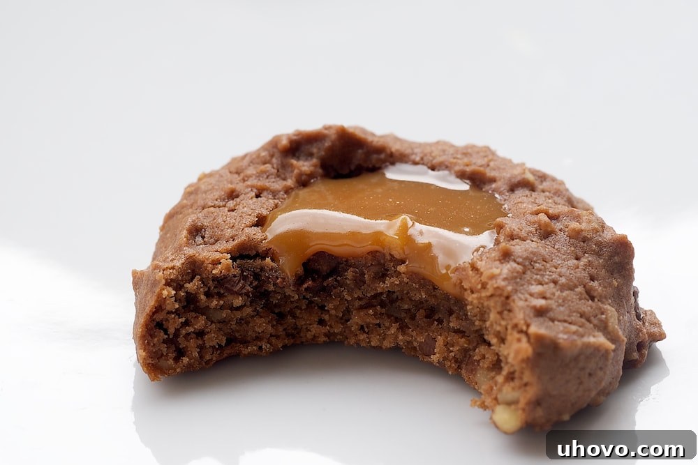 Delightful Turtle Cheesecake Thumbprint Cookies artfully arranged on a serving plate, showcasing their rich chocolate base, caramel filling, and pecan topping – a perfect holiday dessert!