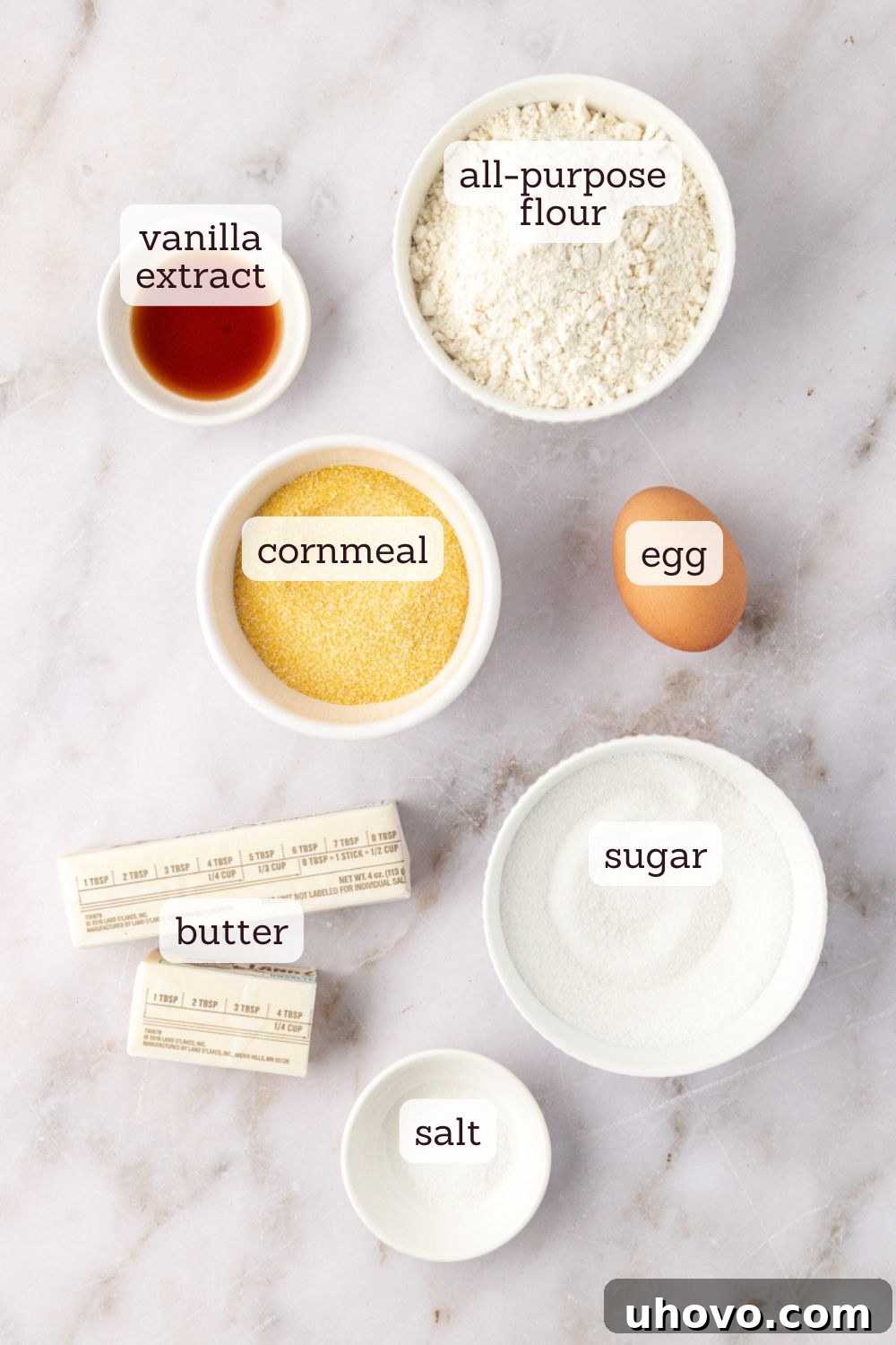 overhead view of essential ingredients for cornmeal cookies laid out on a baking surface