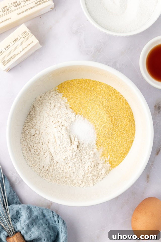 overhead view of flour, cornmeal, and salt measured into a mixing bowl, ready to be combined