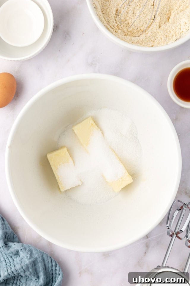 overhead view of softened butter and granulated sugar being creamed together in a mixing bowl