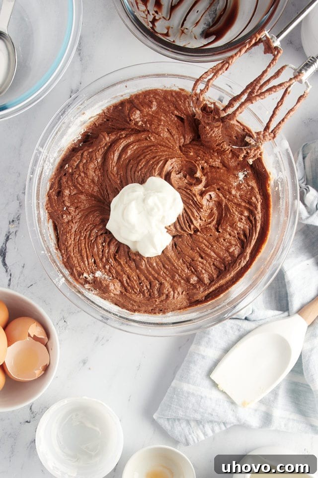 overhead view of sour cream added to chocolate cake batter