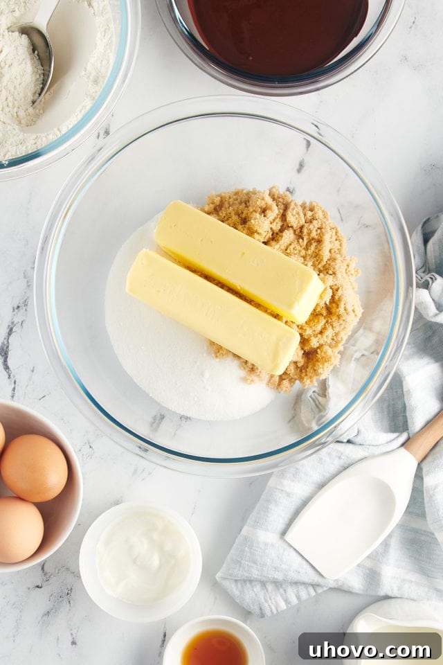overhead view of butter, sugar, and brown sugar in a glass mixing bowl