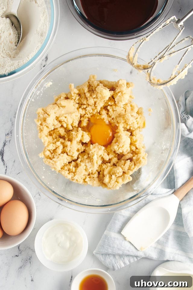 overhead view of egg added to creamed butter and sugar