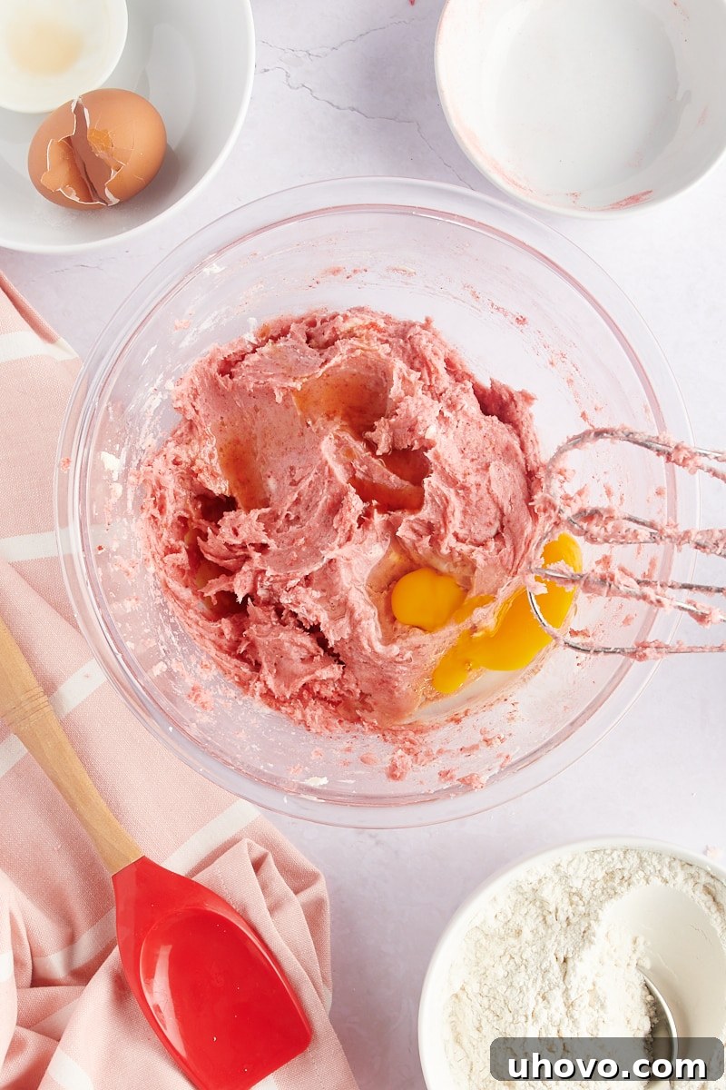 overhead view of an egg added to strawberry cookie dough