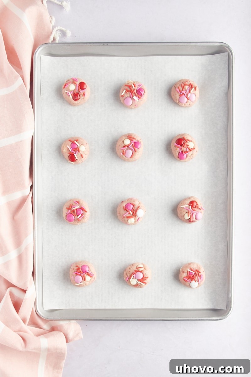 overhead view of Strawberry M&M Cookie dough on a parchment-lined baking sheet