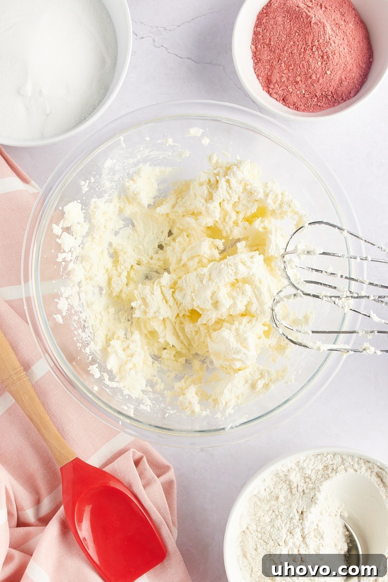 overhead view of creamed butter and cream cheese in a glass mixing bowl
