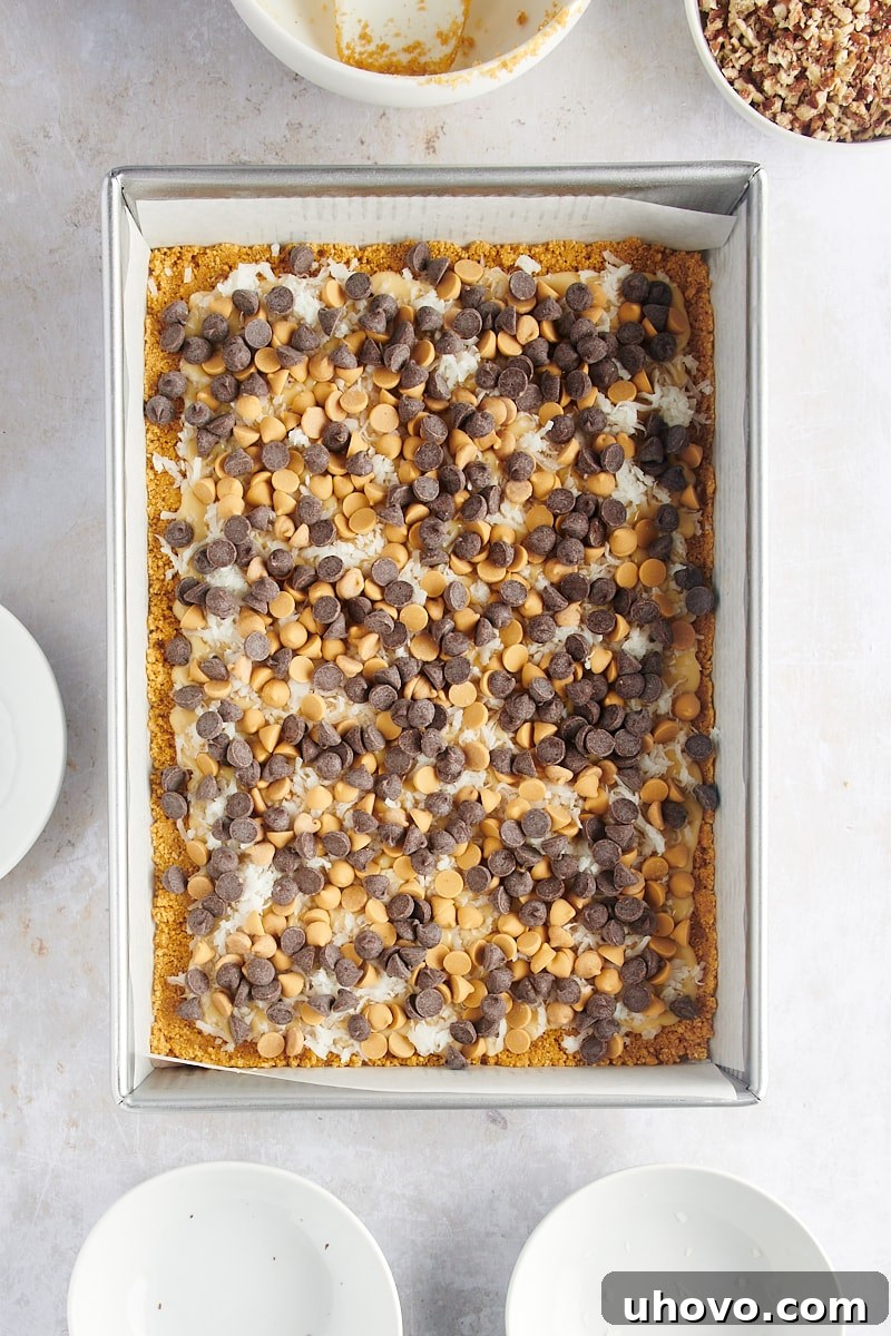 Overhead view of seven layer bars after sprinkling chocolate chips over the other layers