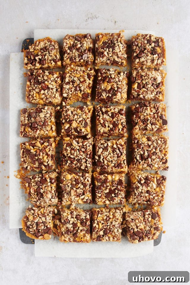 Perfectly cut seven layer bars arranged on parchment paper, ready to serve